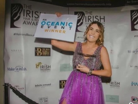 Holding up a "winner" card at the Irish Hair & Beauty Awards photo wall.