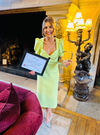 Louisa Murphy holding a Network Ireland Wexford Businesswoman of the Year 2025 certificate and a glass trophy.